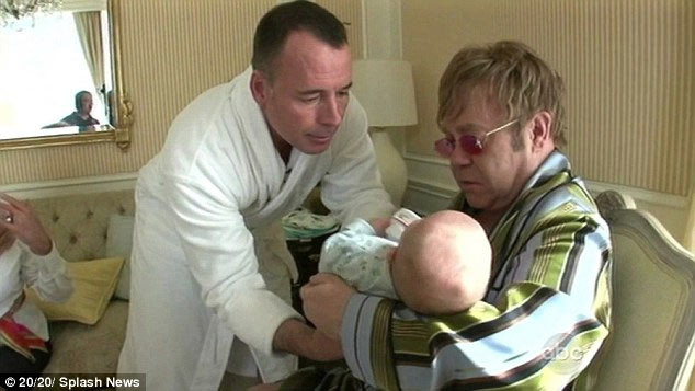 Hai ông bố cho bé Zachary uống sữa từ người mẹ mang thai hộ. Sữa được vắt từ người phụ nữ đẻ thuê cho Elton rồi được chuyển phát nhanh tới nhà nam ca sĩ để em bé uống.