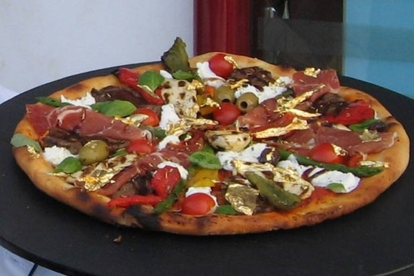 Pizza trứng cá muối Caviar sâm-panh và vàng vụn ở Rome, Ý: Nhân của chiếc bánh này bao gồm trứng cá muối ngâm rượu sâm-panh Dom Perignon, cá hồi hun khói Scotland, tôm hùm ướp trong cognac, thịt nai hảo hạng, thịt giăm bông prosciutto nổi tiếng và giấm lâu năm. Ở bước cuối cùng, nó còn được rắc thêm những lát vàng vụn 24k. Ảnh: Internet.