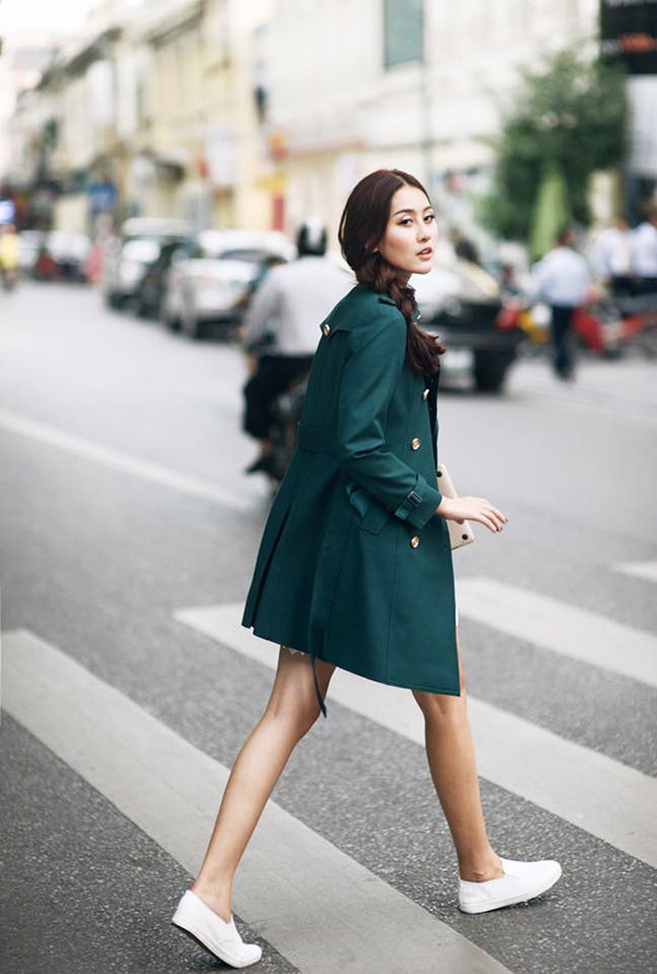 Hà Lade hóa quý cô thanh lịch nhờ phối chiếc áo măng tô màu xanh lạ mắt với giày slip on trắng.