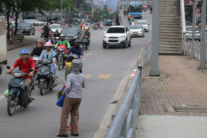 Khách hàng băng qua hàng rào sau khi sử dụng xe bus BRT, bất chấp có cầu vượt ngay cạnh. Hành động này vừa gây nguy hiểm cho bản thân và tiềm ẩn tai nạn giao thông cho người khác. Theo Bộ luật Hình sự, từ 1/1/2018, người tham gia giao thông nói chung và người đi bộ nói riêng vi phạm quy định về an toàn giao thông đường bộ gây ra các vụ tai nạn nghiêm trọng có thể bị phạt tù 7-15 năm.