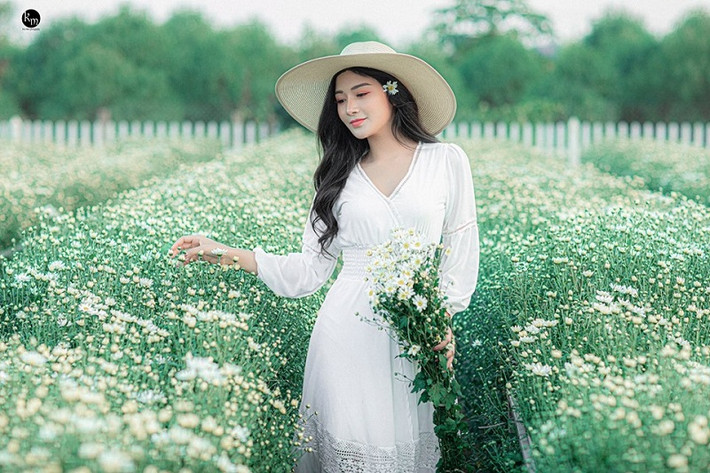 Sau đó, chỉ với một chiếc váy trắng và mũ đơn giản, cô nàng hot girl vẫn nổi bật như một nàng thơ giữa vườn hoa.