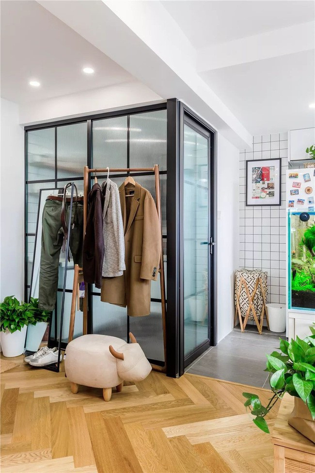 Ngôi nhà được trang trí mang đậm phong cách Bắc Âu với tường trắng, cửa kính lớn, sàn gỗ.