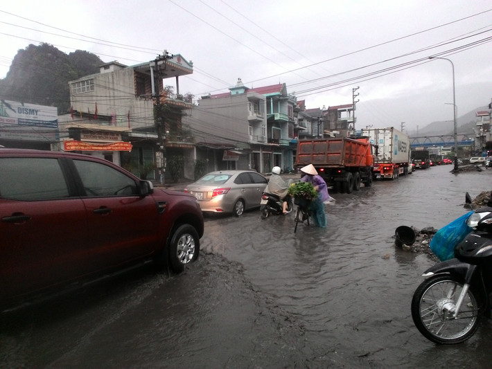 Nước ngập mặt đường đã khiến việc đi lại của người dân gặp nhiều khó khăn. Nhiều phương tiện phải ì ạch để vượt qua con đường ngập nước.