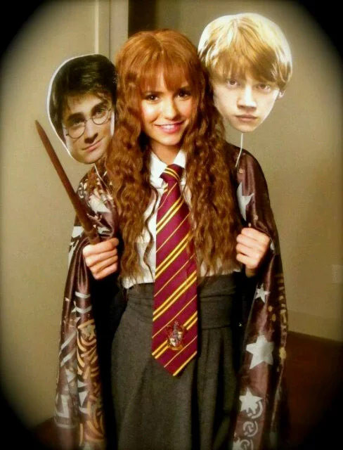 Nina Dobrev phục trang y hệt cô phù thủy nhỏ Hermione Granger, tay còn cầm hai chiếc mặt nạ hình Harry Potter và Ron Weasley trong lễ hội ma quỷ năm 2011. (Ảnh: Getty Images).