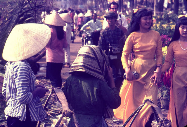 Vẻ đẹp rạng rỡ, đầy sức sống của những cô gái ở Sài Gòn trong tà áo dài trong một khu chợ.