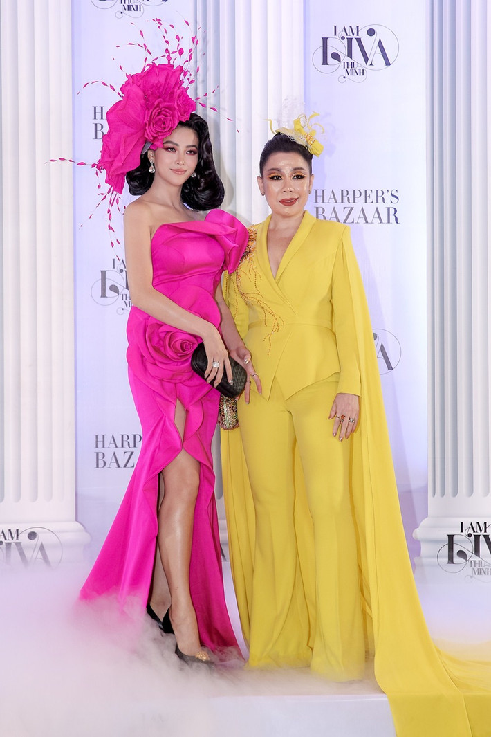Hoa hậu Phương Khánh rực rỡ trong thiết kế đầm dài xẻ tà màu hồng fuchsia. Đứng cạnh cô là NTK Linh San với bộ cánh màu vàng neon cũng nổi bật không kém.
