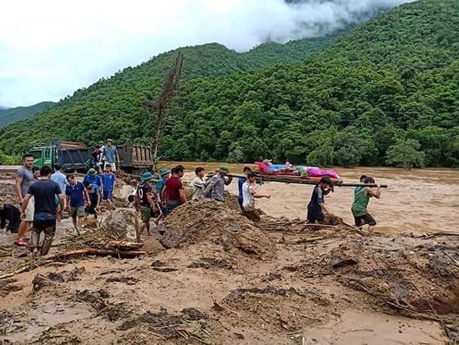 Người dân cùng cơ quan chức năng hỗ trợ tìm kiếm thi thể người bị đất đá sạt lở vùi lấp.