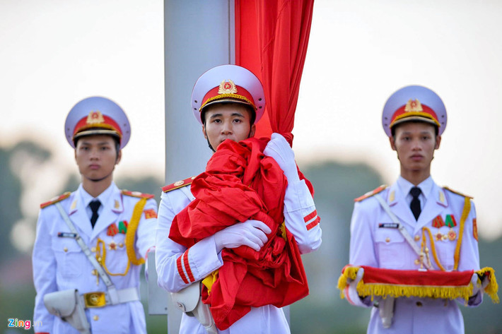 Thượng cờ là nghi lễ cấp quốc gia được thực hiện mỗi ngày vào lúc 6h mùa hè và 6h30 mùa đông. Người dân khi đi qua Quảng trường Ba Đình đều đứng trang nghiêm. Ảnh: Việt Hùng.