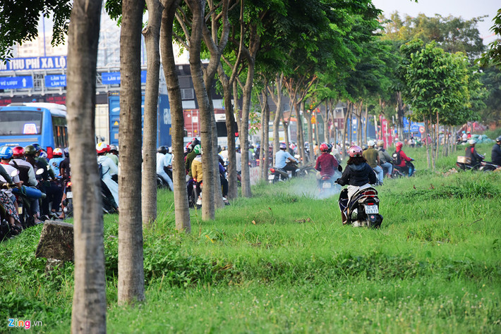 Những bãi cỏ xanh mướt đoạn từ đường Tây Hòa đến chân cầu Rạch Chiếc trở thành lối thoát cho nhiều người chạy xe máy khi ngã tư này ùn tắc nghiêm trọng.