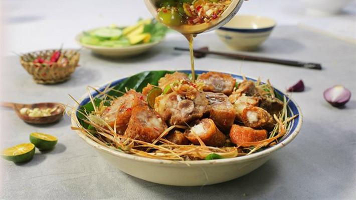 Sau đó bắc chảo dầu lên cho nóng và thả đuôi heo vào chiên giòn. Hành tím, hành tây, hành lá, ớt sừng cho vào chảo xào và cho đuôi heo vào tiếp, xào khoảng 1 phút cho ra đĩa, rắc muối ớt cay lên mặt. Món này có thể ăn kèm cùng đồ chua. Ảnh: Internet.