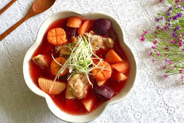 Phi thơm một ít hành khô băm nhỏ, cho đuôi lợn vào đảo săn cùng một ít nước mắm. Sau đó cho tiếp khoai tây, cà rốt và củ dền vào đảo qua rồi chế lượng nước đủ ăn vào. Đun liu riu nhỏ lửa, ninh khoảng 15 phút thì cho hành hoa và mùi thái nhỏ vào và tắt bếp.