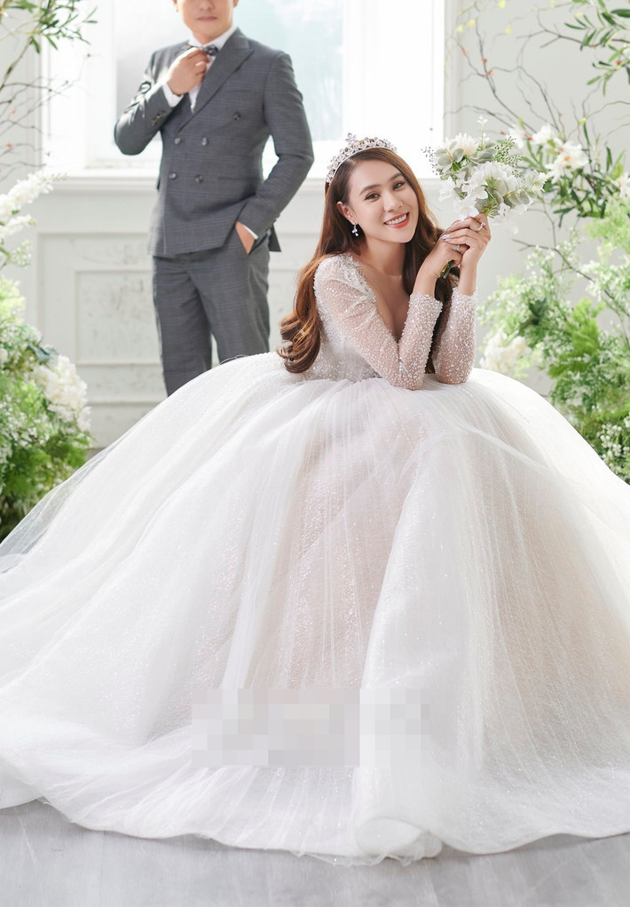Hồ Bích Trâm diện mẫu váy cưới bồng xòe, đính 4.000 viên đá pha lê và đội vương miện. Trong bộ ảnh cưới, nữ diễn viên giấu kín danh tính và khuôn mặt của chồng. Chia sẻ với Zing, cô cho biết: "Ông xã là người hiền lành, không thích ồn ào hay xuất hiện trên truyền thông. Vì thế, tôi tôn trọng mong muốn của anh".