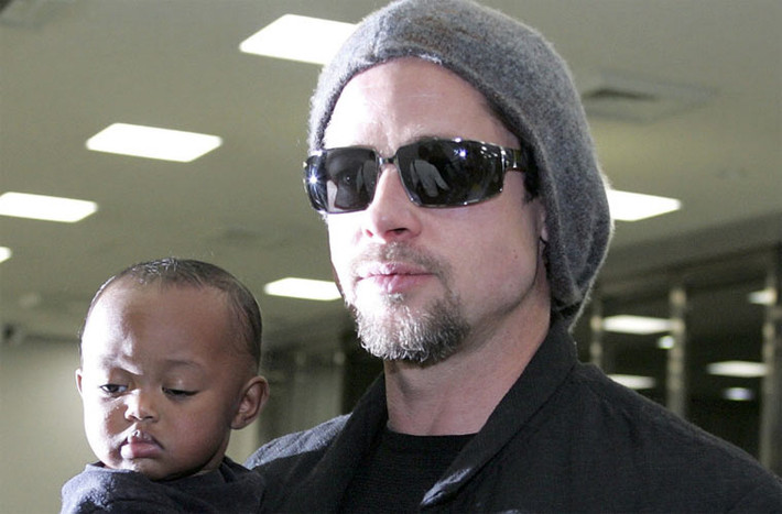 Sau khi chia tay Aniston, không lâu sau đó, cánh săn ảnh lại chộp được anh chụp ảnh cùng Angelina Jolie và hai con nuôi của cô, Maddox và Zahara. Trong ảnh là Brad Pitt bế Zahara ở sân bay Tokyo tháng 11/2005. (Ảnh: CNN)