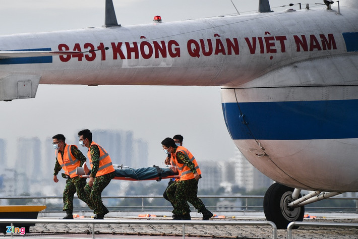 Ê-kíp cấp cứu đường không gồm 4 người, nhanh chóng vận chuyển bệnh nhân ra ngoài bằng băng ca.