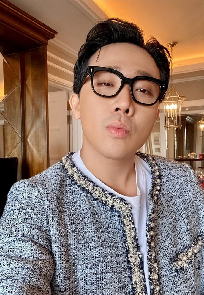 Trấn Thành gây chú ý khi đeo kính, diên áo đính kết hạt cầu kỳ. Cư dân mạng trêu chọc nam MC đang diện nhầm đồ của bà xã Hari Won.