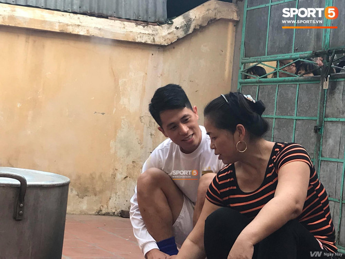 Trong khi đó, Đình Trọng ngồi bên bếp bánh chưng của mẹ Duy Mạnh để hỏi thăm và lắng nghe những chia sẻ trong cuộc sống. Ảnh: Sport5.