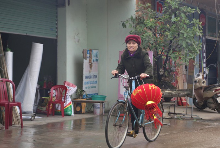 Một phụ nữ mua đèn lồng về trang trí nhà cửa đón Tết. Cũng như khắp mọi miền đất nước, Xuân đang về với thôn Hoành.