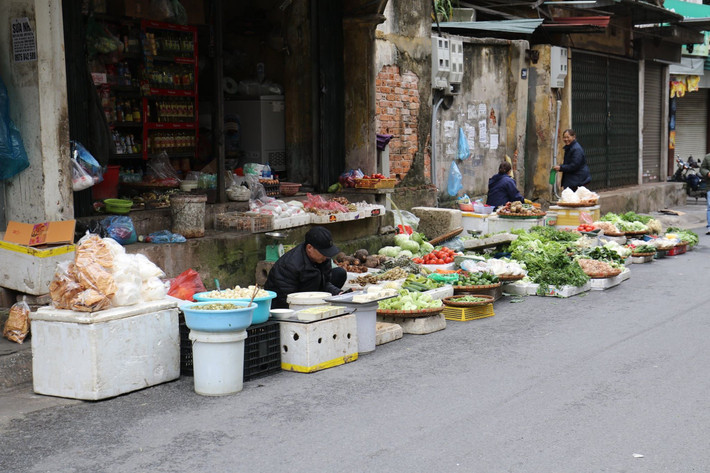 Khung cảnh đìu hiu trước một cửa hàng bán rau củ quả. Các tiểu thương tranh thủ chúc Tết, trao đổi với nhau giá cả các mặt hàng...