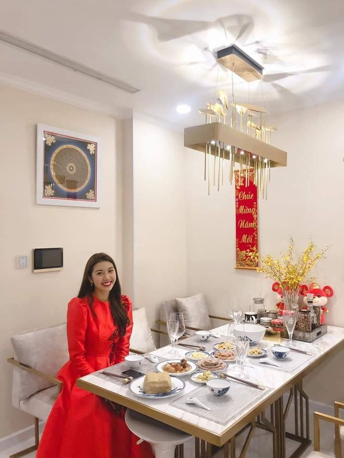 Không gian bàn ăn của Á hậu Thúy Vân được trang trí đơn giản với câu chúc Tết và lọ hoa mai vàng