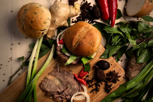 Món ăn có sự kết hợp của ổ bánh mì tròn được ướp cùng 22 gia vị chuyên dùng để nấu phở, phần nhân bằng thịt bò. Kết nối nhân và vỏ bánh là các loại rau thơm như húng, bạc hà, ngò gai và vài sợi phở... Ảnh: Ivivu.