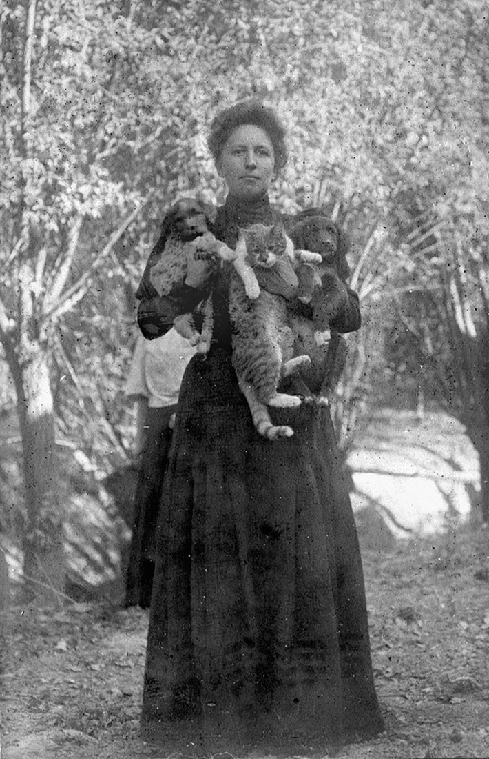 Vera Smirnova ôm mèo cưng và chó. Bức ảnh được chụp vào khoảng năm 1906 - 1910.