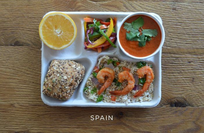 Trẻ em Tây Ban Nha ăn trưa tại trường gồm cơm gạo lứt rang tôm rau, súp lạnh gazpacho, ớt tươi, bánh mì và cam.
