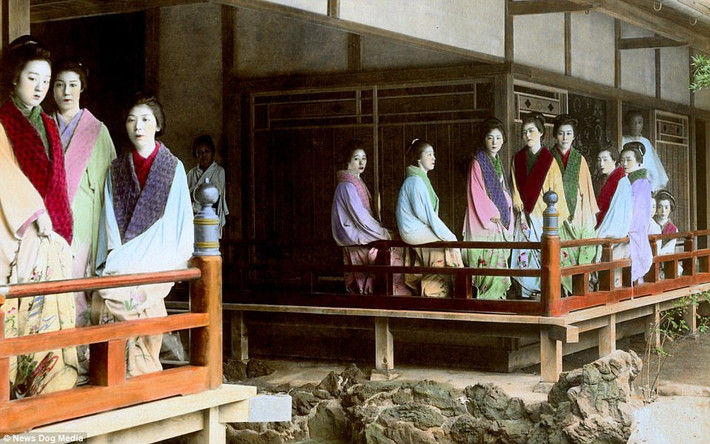 Các kỹ nữ đứng bên ngoài nhà thổ tại Yoshiwara. Khu phố đèn đỏ Yoshiwara hoạt động cho tới năm 1958. Sau đó, chính phủ Nhật Bản ra lệnh cấm.