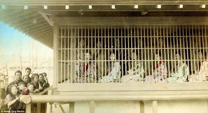 Các kỹ nữ trang điểm lộng lẫy ngôi trong "lồng gỗ" chờ đợi khách hàng tìm đến.