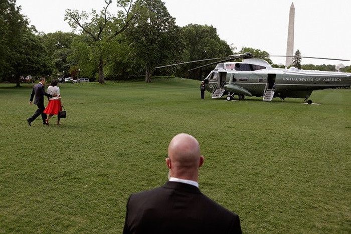 Một vệ sĩ bảo vệ Tổng thống Obama và phu nhân lên trực thăng.