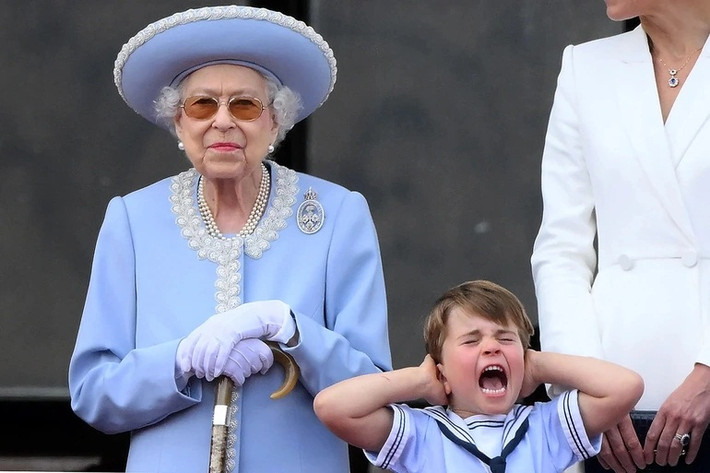 Hoàng tử Louis lấy tay bịt tai vì tiếng ồn máy bay lúc đứng cạnh Nữ hoàng Elizabeth II trên ban công Điện Buckingham.