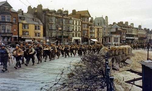 Binh sĩ thuộc Quân đội Mỹ hành quân qua một thị trấn của Anh hồi tháng 6/1944.