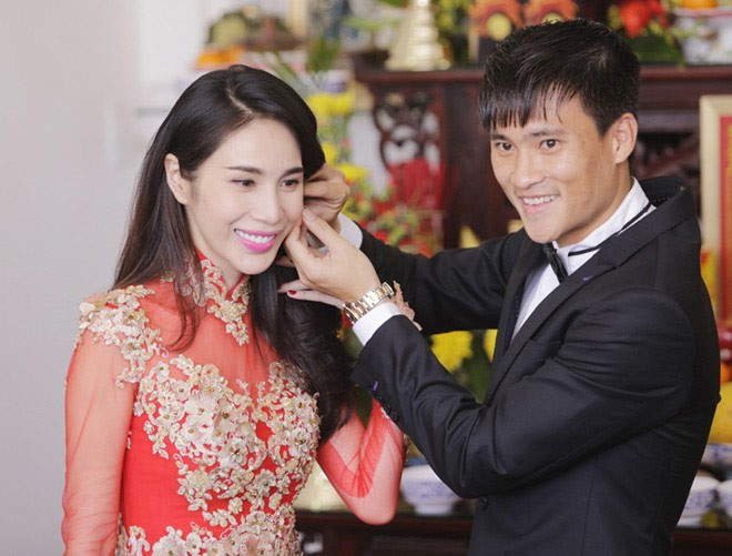 Cặp đôi rạng ngời hạnh phúc trước ống kính. Sau khi trao nhẫn, Công Vinh đeo bông tai cho vợ. Chia sẻ về chiếc áo dài, NTK Minh Châu cho biết, vì cô dâu mong muốn hôn lễ theo phong cách truyền thống, trang trọng nên họ chọn màu đỏ làm chủ đạo. Nhà thiết kế đã sử dụng vải voan đỏ để may áo dài cô dâu vì Thủy Tiên có vóc dáng đẹp, thanh mảnh. Chất liệu xuyên thấu sẽ khoe được ưu điểm của bà mẹ một con.