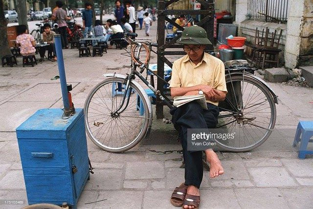 Trong lúc không có khách, một người đàn ông sửa xe ngồi đọc báo trên vỉa hè trên phố Trần Hưng Đạo, thành phố Hà Nội. Báo giấy cung cấp nhiều thông tin quan trọng về các lĩnh vực như xã hội, kinh tế, văn hóa... hàng ngày cho người dân.