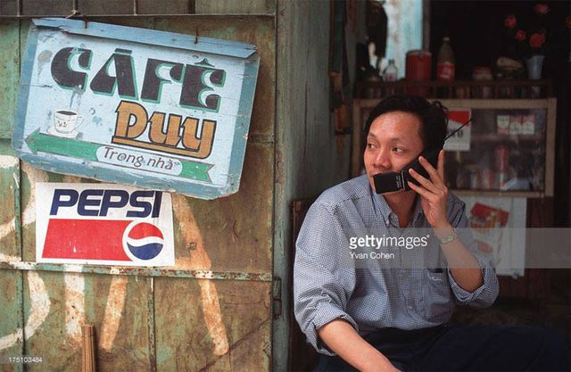 Một người đàn ông ở Hà Nội dùng điện thoại di động. Vào thời điểm năm 1996, điện thoại di động chưa phổ biến nên có giá khá đắt.