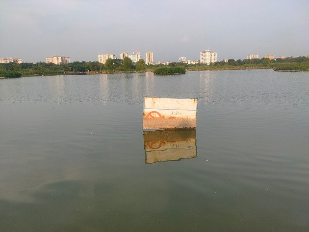 Tấm biển cảnh báo được cắm tại khu vực sát mép nước đã gỉ sét, không còn đọc rõ chữ.