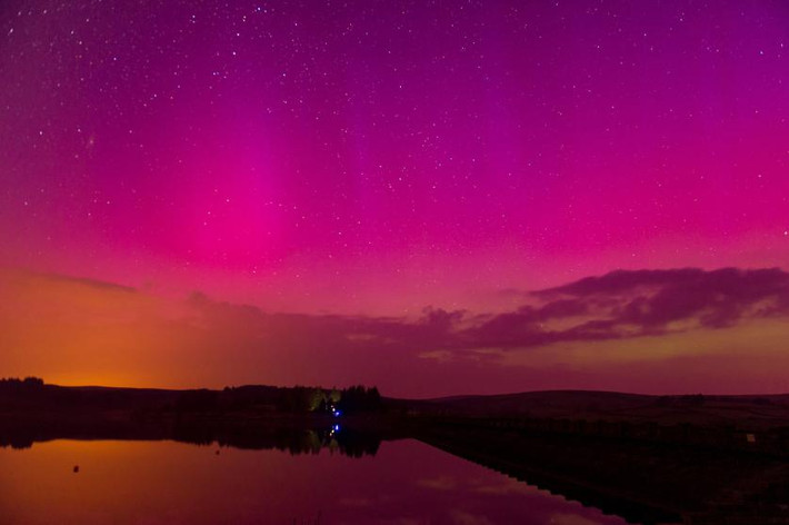 Cực quang Aurora Borealis (Ánh sáng phương Bắc) nhuộm hồng cả bầu trời và mặt đất ở Brecon Beacons, Wales, Anh. Hình ảnh được chụp vào ngày 17/3/2015.