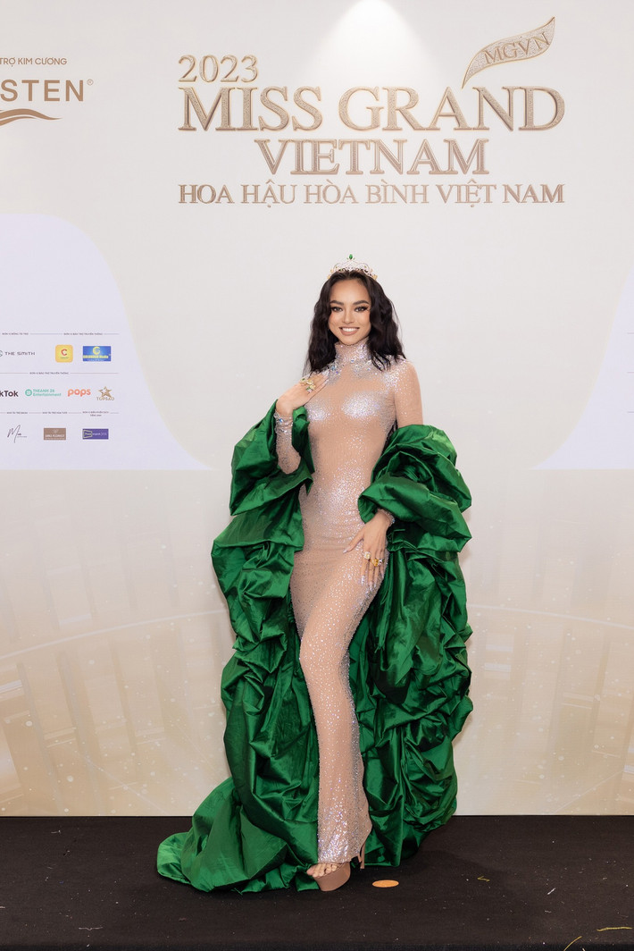 Á hậu Mai Ngô diện váy tông màu nude kết hợp áo choàng xanh.