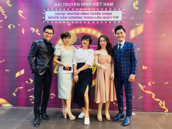 Nữ MC tài năng trẻ trung với áo sơ mi trắng phối cùng chân váy xẻ cao khoe chân dài.