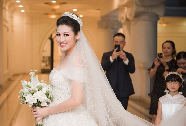 Chiếc váy cưới của Á hậu Tú Anh là sáng tạo của nhà thiết kế Chung Thanh Phong, được lấy cảm hứng từ nàng công chúa Lọ Lem với phom dáng xoè bồng bềnh.