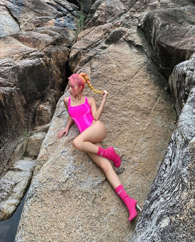 Quỳnh Anh Shyn nổi bật khi diện bodysuit màu hồng neon mix cùng bốt và màu tóc cùng tông.