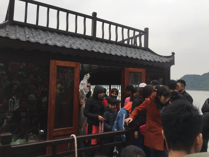 ...Du khách từ thuyền lên ngôi chùa giữa đảo.