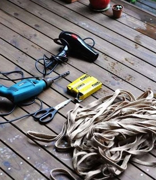 Đầu tiên, bạn cần chuẩn bị máy khoan, máy sấy tóc, kéo, keo dán công nghiệp, dây bện bản dẹt và một chiếc lốp xe ô tô cũ.