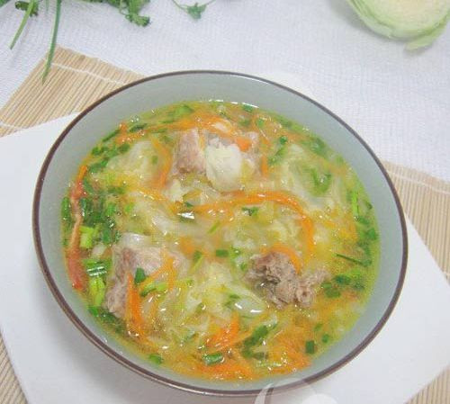 Nóng hổi canh chua bắp cải nấu sườn. Bắp cải thái mỏng, rửa sạch, cà rốt gọt bỏ vỏ, rửa sạch rồi nạo thành sợi. Cà chua, rửa sạch, bổ múi cau. Hành hoa và rau mùi nhặt bỏ rễ và lá già, rửa sạch rồi thái nhỏ, phần gốc hành trắng thái nhỏ để riêng. Tất cả những nguyên liệu này mang nấu với sườn heo tạo nên món ăn hấp dẫn và giàu chất dinh dưỡng. Ảnh: Khám phá.