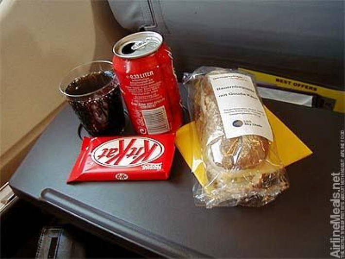 Bữa sáng gồm bánh mỳ sandwich, nước ngọt và một thanh socola.