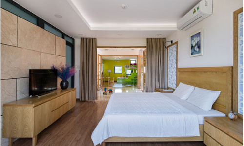 Phòng ngủ cũng khá nhã nhặn với các đồ nội thất gỗ và sơn tường màu trắng.