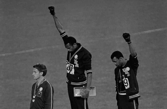Hai vận động viên Tommie Smith và John Carlos giơ một cánh tay lên trong khi nhận huy chương là cách thể hiện nhân quyền của họ trước toàn thế giới, khi mà tại xứ sở cờ hoa những quốc dân da màu như họ đang phải hứng chịu nạn phân biệt chủng tộc. Bức ảnh này được chụp tại thế vận hội Olympic 1968 ở Mexico.