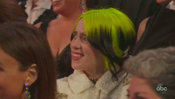 Biểu cảm gây cười của Billie Ellish trước màn trình diễn của Maya Rudolph và Kisten Wiig. Billie Eilish đến dự Oscar trong hình ảnh nổi loạn và cá tính. Giới mộ điệu ví cô như thể vừa bước ra khỏi giường với "cây" Channel vô cùng sang chảnh, kèm theo đó là bộ móng tay đen đính hạt thủy tinh cùng màu tóc xanh neon đang được giới trẻ yêu thích.