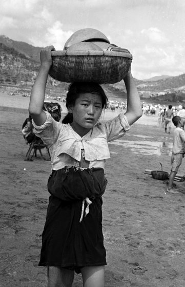 Một phụ nữ Triều Tiên mang đồ đạc rời khỏi quê hương ngày 6/8/1950.