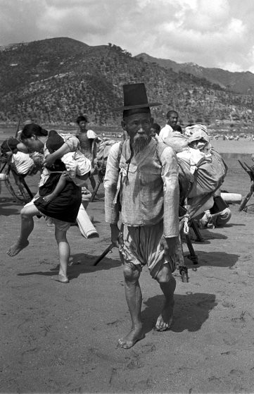 Già trẻ, trai gái ở Triều Tiên mang theo hành lý rời khỏi vùng đất chiến sự năm 1950.
