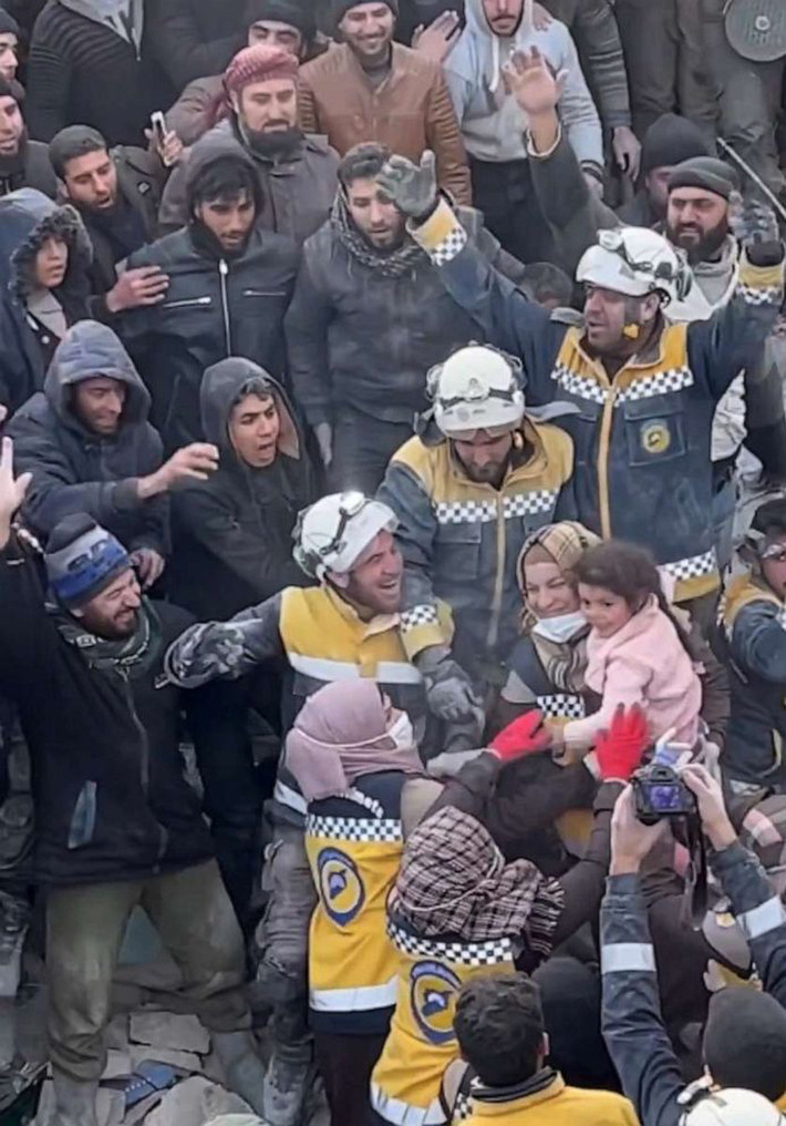 Một bé gái ở khu vực Idlib của Syria, được đội cứu hộ tình nguyện kéo ra khỏi đống đổ nát của một tòa nhà trong tiếng reo hò của đám đông. Ảnh: Ảnh: ABC NEWS.